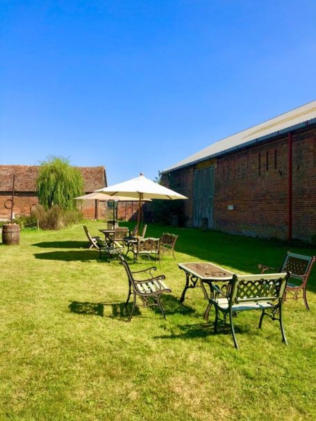 Outdoor seating area with tables and chairs under a sunny blue sky.